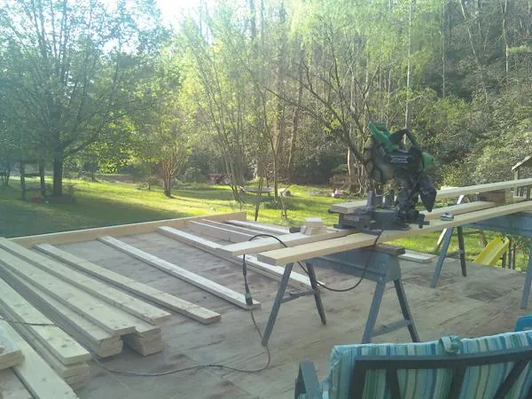 Miter saw and framing lumber on a deck under construction in Seneca